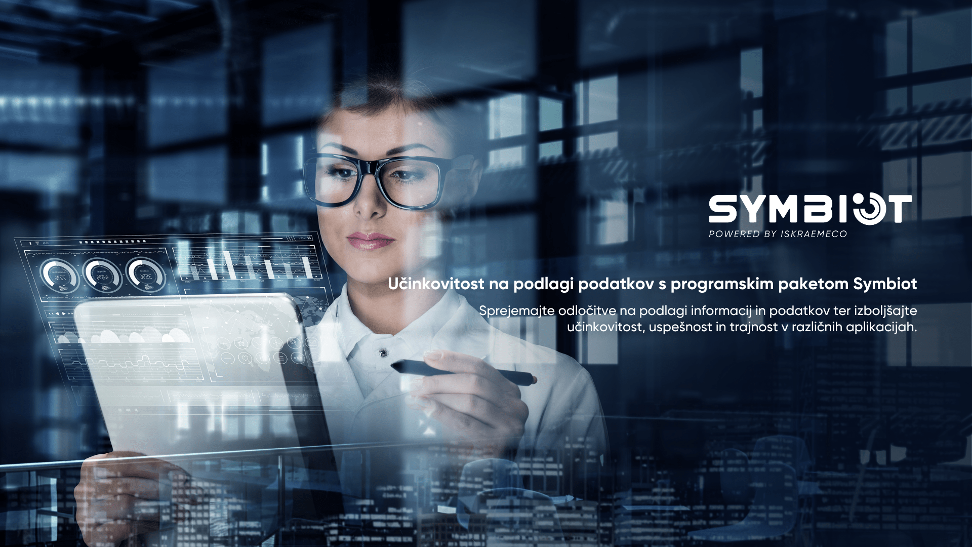 Woman with glasses in front of a screen with digital dashboard and text for Symbiot introduction in Slovenian
